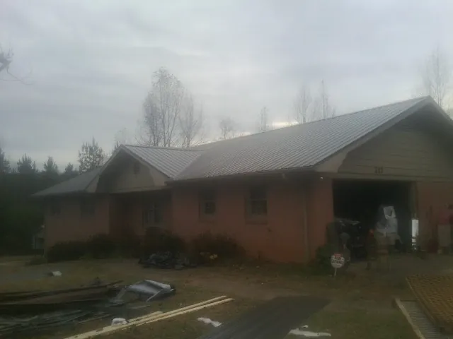 Gray metal roof on a stucco house with an attached garage in Spencer